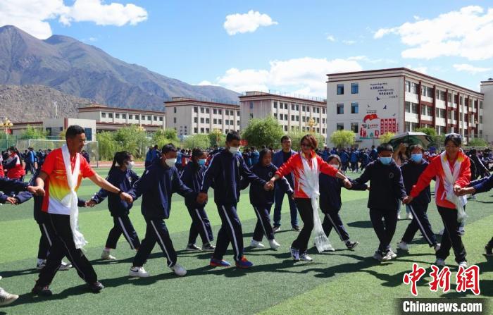 圖為世界冠軍與拉薩阿里地區(qū)高級中學(xué)學(xué)生一起跳鍋莊。　冉文娟 攝