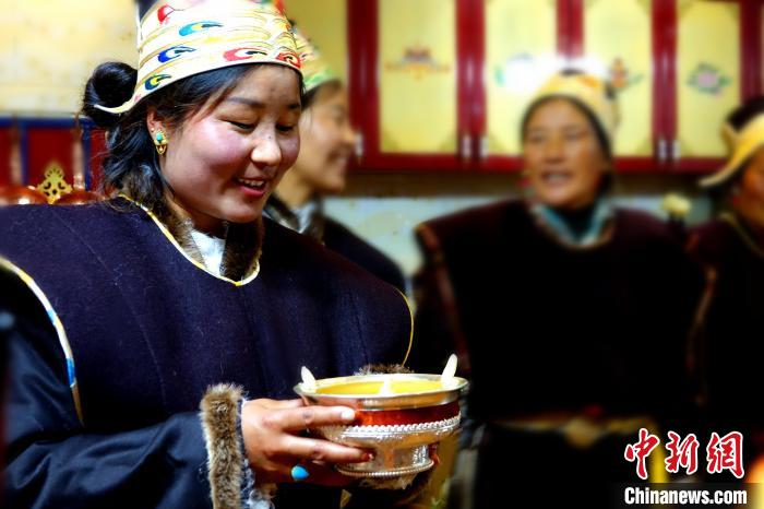圖為藏族姑娘向客人敬酒?！∪轿木?攝