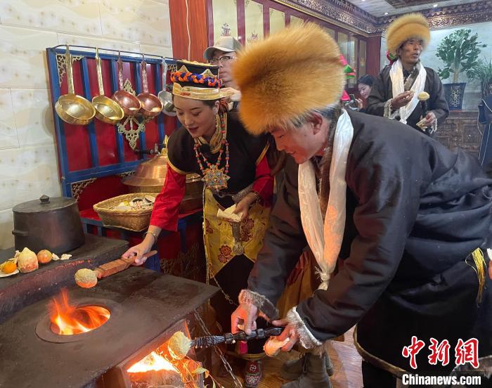 圖為人們?cè)诨鹕峡竟?jié)日美食“結(jié)達(dá)”?！∪轿木?攝