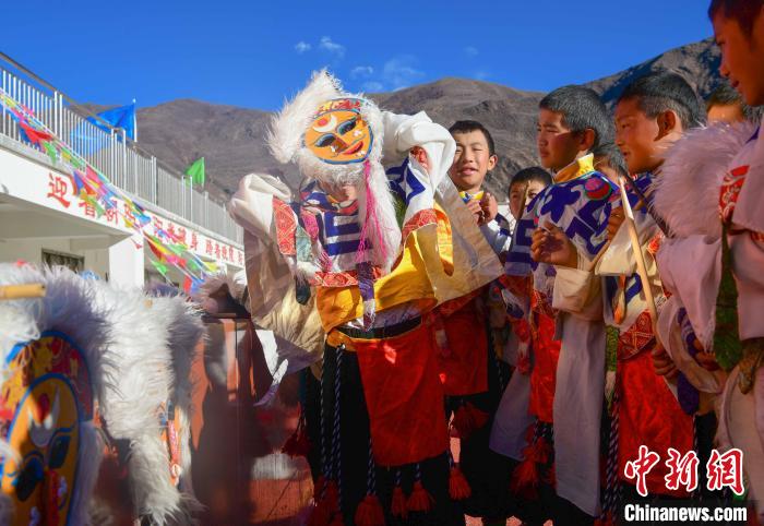 圖為加查縣安繞鎮(zhèn)小學學生在試穿藏戲面具?！∝暩聛硭?攝