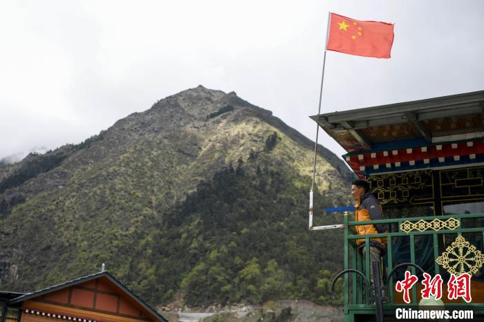 村民站在樓房上觀望。　楊華峰 攝