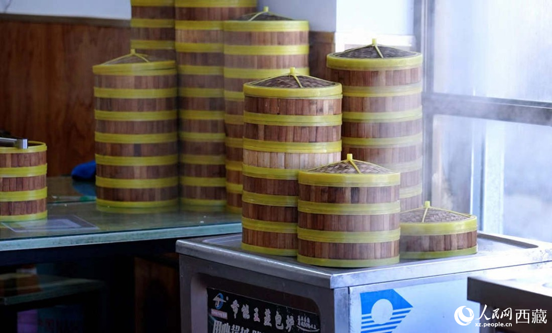 電蒸箱上擺滿了多屜熱氣騰騰的包子。人民網(wǎng) 次仁羅布攝