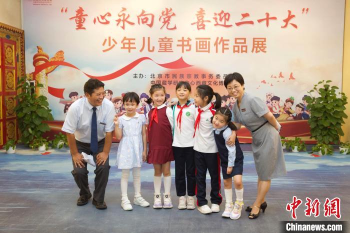 圖為與會嘉賓與入選畫作的“小作者”們在展覽上合影?！≈袊貙W(xué)研究中心供圖