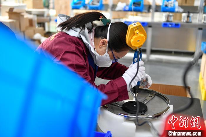 圖為工人正在組裝炊具?！∝暩聛硭?攝