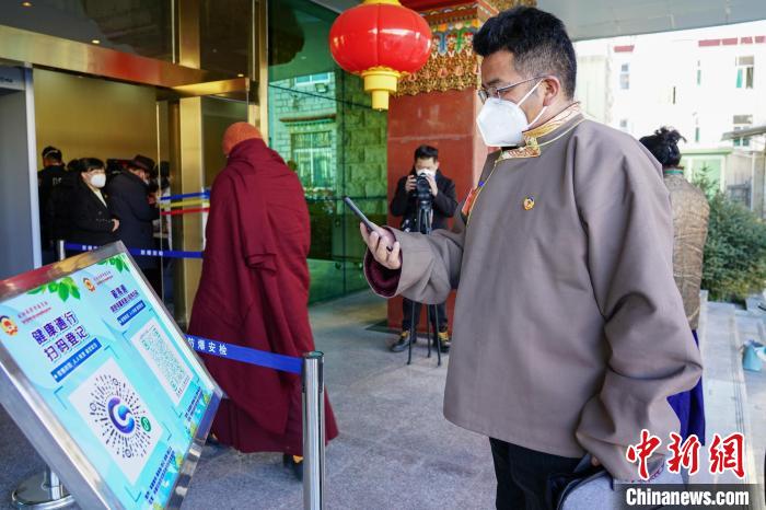 圖為政協(xié)委員掃場(chǎng)所碼進(jìn)入會(huì)場(chǎng)?！〗w波 攝