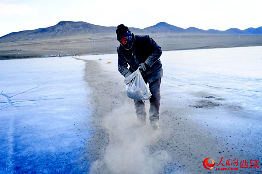 牧民在冰面上撒灰鋪成通道。人民網(wǎng) 李海霞攝