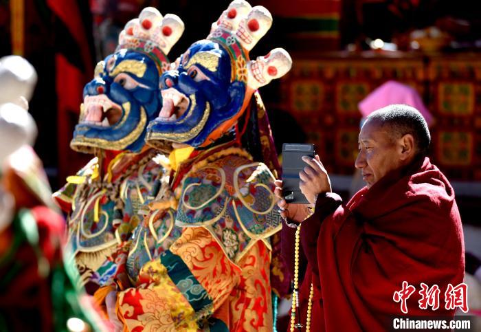 2月19日，正在拍攝跳神活動(dòng)的僧人?！±盍?攝