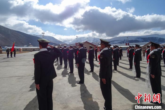 雪山下，退役士兵向軍旗敬軍禮。　李學(xué)文 攝