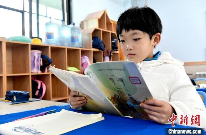 3月14日，西藏拉薩市第一小學一年級六班學生丁增樂吉在閱讀藏語課本。　李林 攝