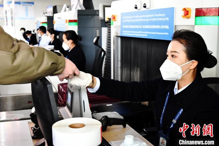 圖為機(jī)場(chǎng)工作人員為旅客辦理行李托運(yùn)。　周航 攝