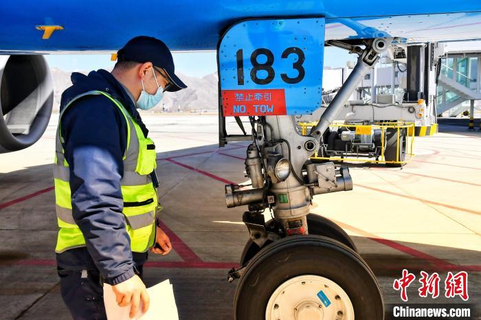 圖為機(jī)場(chǎng)工作人員進(jìn)行相關(guān)檢查。　周航 攝