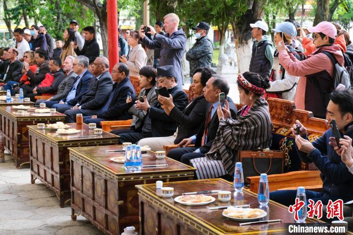 5月19日，中外嘉賓在羅布林卡和游客一起觀看藏戲?！〗w波 攝