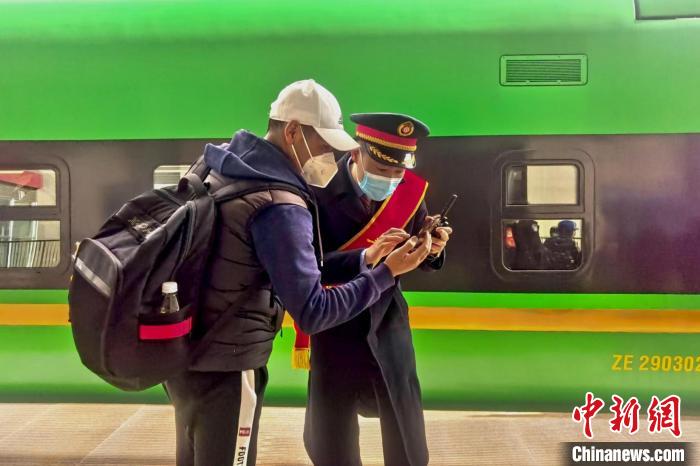 圖為日喀則火車站工作人員服務(wù)乘客?！《飞降?攝