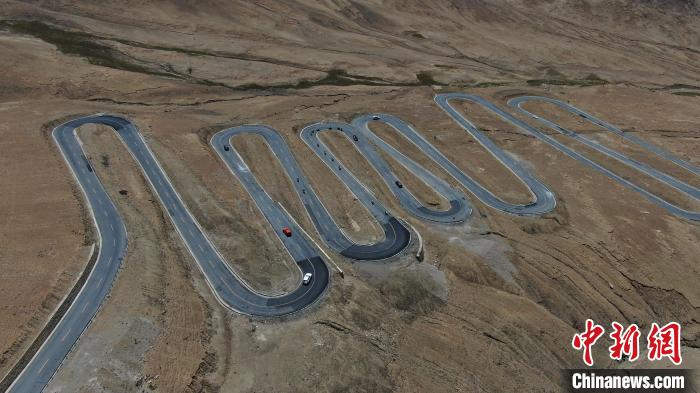 圖為騎手前往珠峰大本營(yíng)途經(jīng)108道拐?！∮文恋厍蚬﹫D