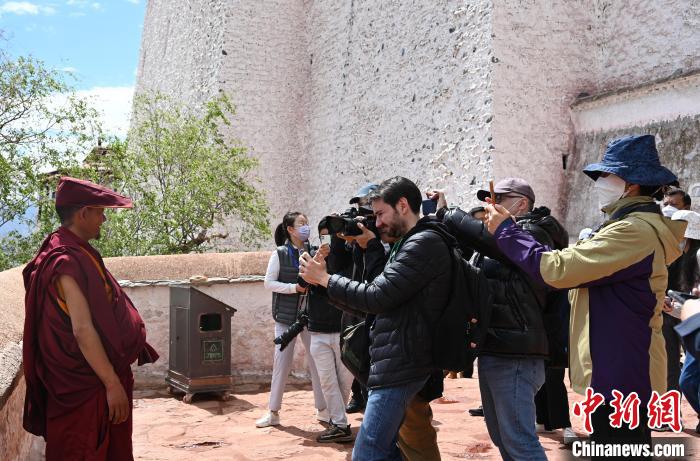 圖為中外媒體拍攝朝拜布達(dá)拉宮的僧人?！≮w朗 攝