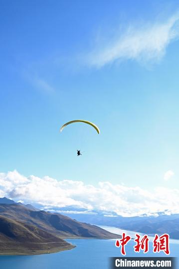 圖為在羊卓雍錯(cuò)，游客體驗(yàn)高空滑翔。　趙朗 攝