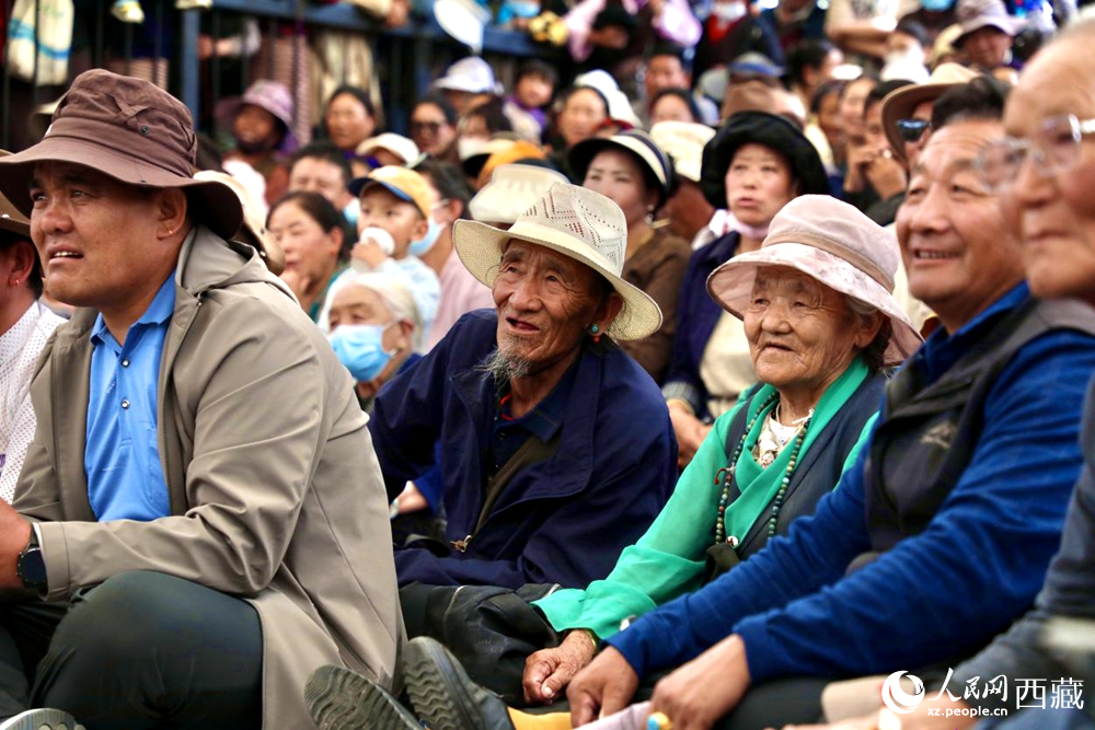 當地群眾和游客觀看藏戲演出。