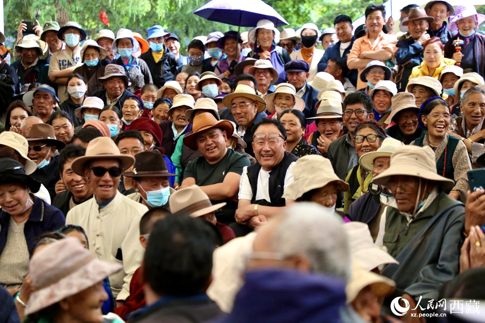 當地群眾和游客觀看藏戲演出。