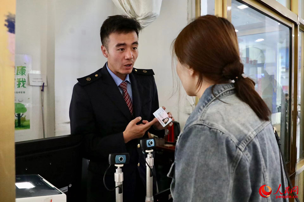 車站工作人員向旅客解答疑問。人民網(wǎng)記者 次仁羅布攝