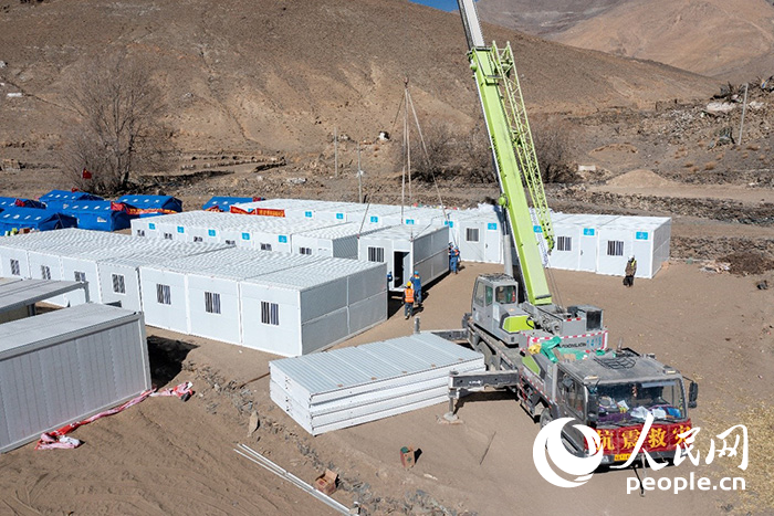 1月9日，在日喀則市定日縣長所鄉(xiāng)古榮村安置點，救援人員和施工人員合力抓緊搭建移動板房，確保受災群眾溫暖過冬。人民網記者 翁奇羽攝