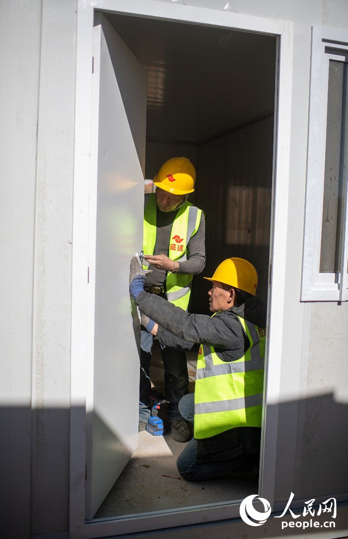 1月9日，在日喀則市定日縣長所鄉(xiāng)古榮村安置點，施工人員正在抓緊搭建移動板房，確保受災群眾溫暖過冬。人民網記者 翁奇羽攝