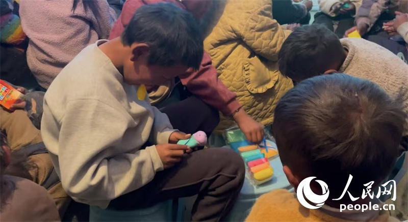 措果鄉(xiāng)塘仁村的孩子們正在用橡皮泥制作自己的情緒“小怪獸”。人民網(wǎng)記者 郝潔攝