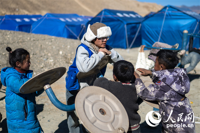 西藏星光社會(huì)工作服務(wù)中心社工久米旦增通過(guò)聊天談心，對(duì)孩子們進(jìn)行災(zāi)后心理疏導(dǎo)。人民網(wǎng)記者 翁奇羽攝
