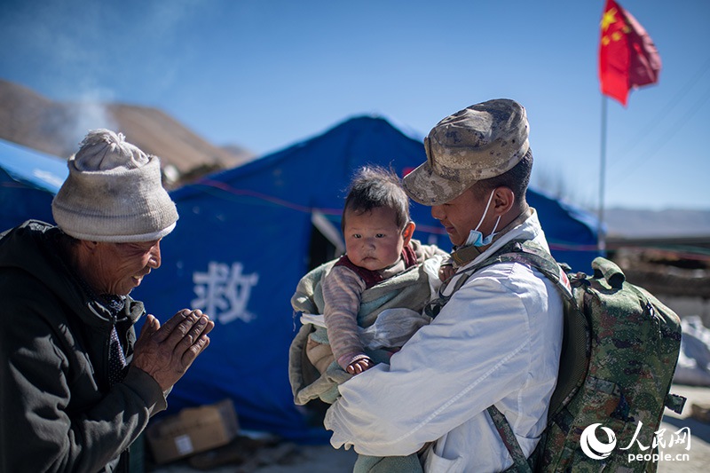 1月9日，在定日縣長(zhǎng)所鄉(xiāng)古榮村安置點(diǎn)，受災(zāi)群眾感謝西藏軍區(qū)陸軍某部隊(duì)衛(wèi)生員的醫(yī)療救治。人民網(wǎng)記者 翁奇羽攝