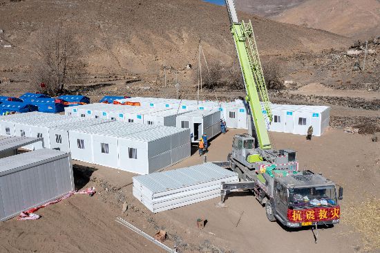 2025年1月9日，在定日縣長所鄉(xiāng)古榮村安置點，救援人員和施工人員合力抓緊搭建移動板房，確保受災群眾溫暖過冬。人民網(wǎng)記者 翁奇羽攝