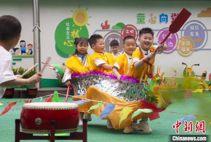 圖為龍舟賽游戲上，小伙伴們打鼓加油?！《^生 攝