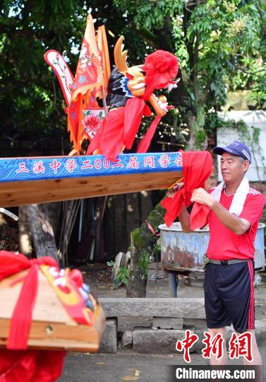 圖為5月29日，長樂江田鎮(zhèn)村民為即將入水的新龍舟系紅布?！埍?攝