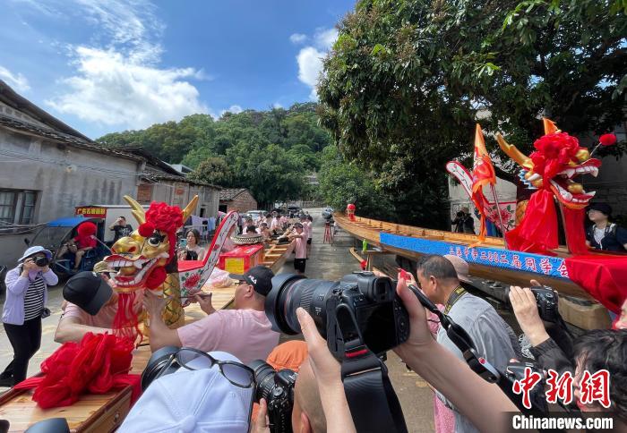 圖為5月29日，長樂江田鎮(zhèn)村民為即將入水的新龍舟安裝龍頭。　張斌 攝