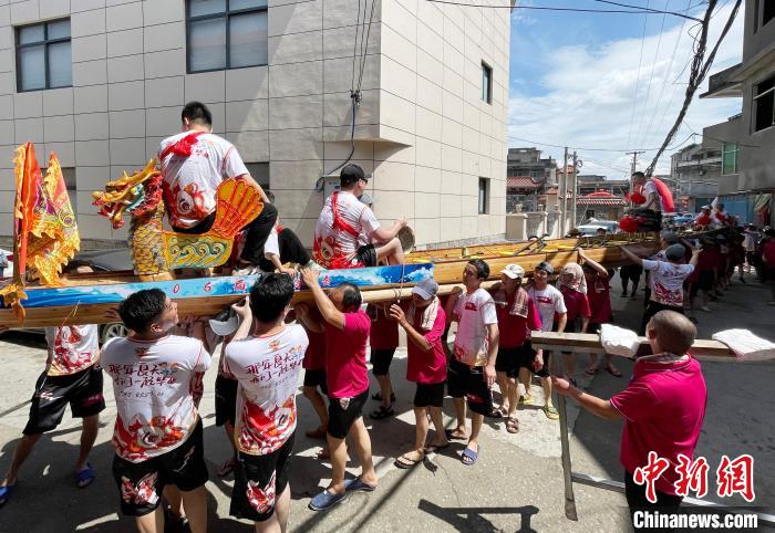 圖為5月29日，長樂江田鎮(zhèn)村民們肩扛著新龍舟舉行入水前游街儀式?！埍?攝