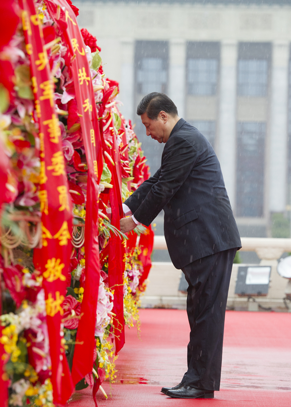 2013年10月1日上午，在首都各界代表向人民英雄紀(jì)念碑敬獻(xiàn)花籃儀式上，習(xí)近平整理花籃上的緞帶。